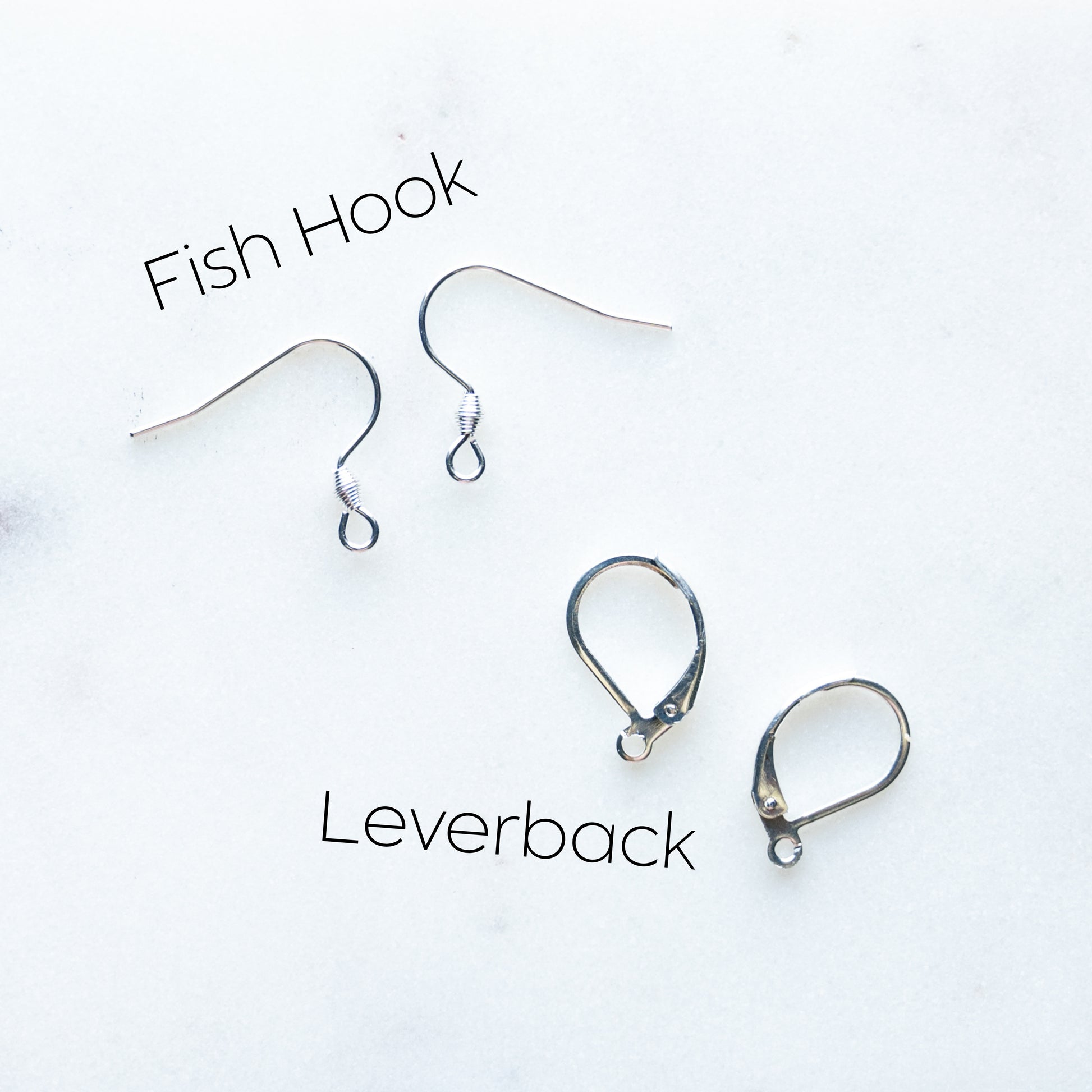 Two pairs of silver earring hardware on a white background: fish hooks at the top and leverbacks at the bottom, with black text labels reading 'Fish Hook' and 'Leverback'.